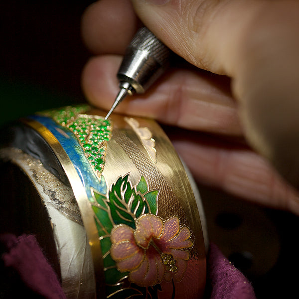 Bespoke bangle with stones and enamel flower and bird designs on it.
